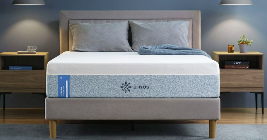 memory foam mattress with pillows on top of a grey bed frame with matching headboard