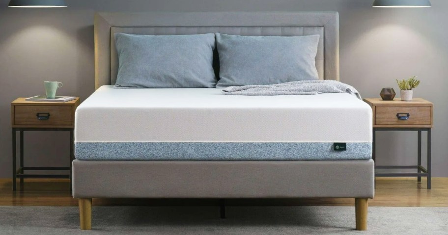 memory foam mattress with pillows on top of a grey bed frame with matching headboard