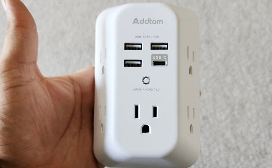 hand holding white outlet extender 