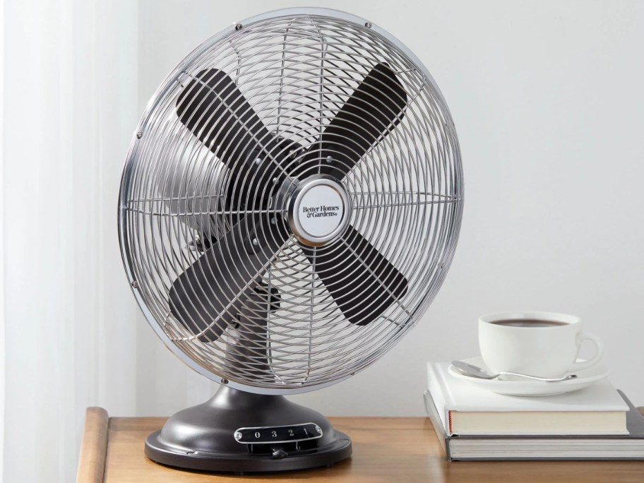 black metal round retro style table fan on a side table