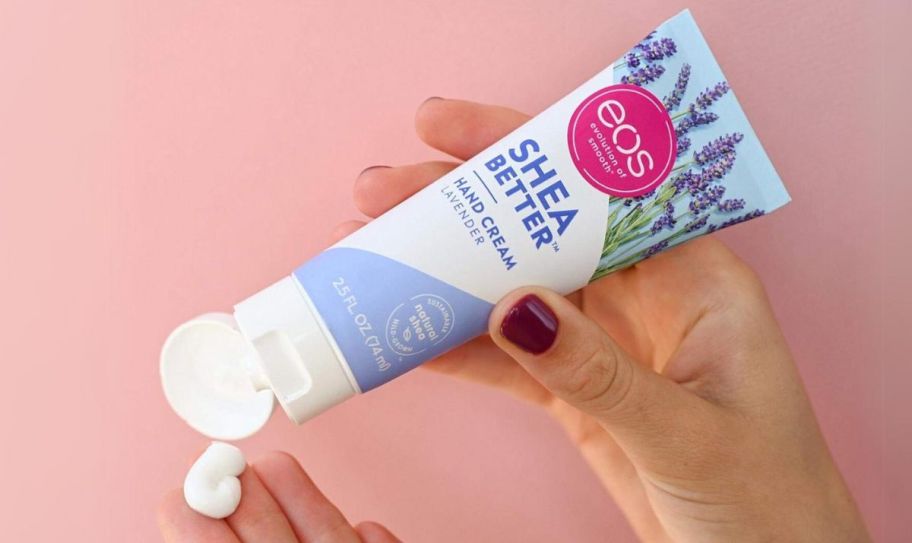 a womans hands dispensing lavender shea butter handcream from a tube