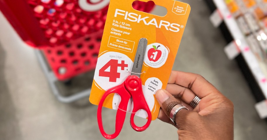 hand holding red fiskars scissors