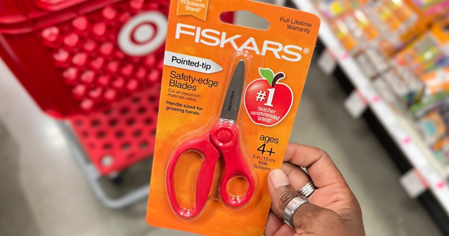 hand holding red fiskars scissors