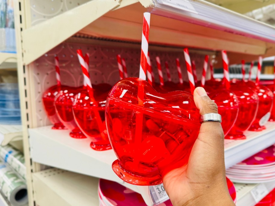 hand holding red tumbler with straw