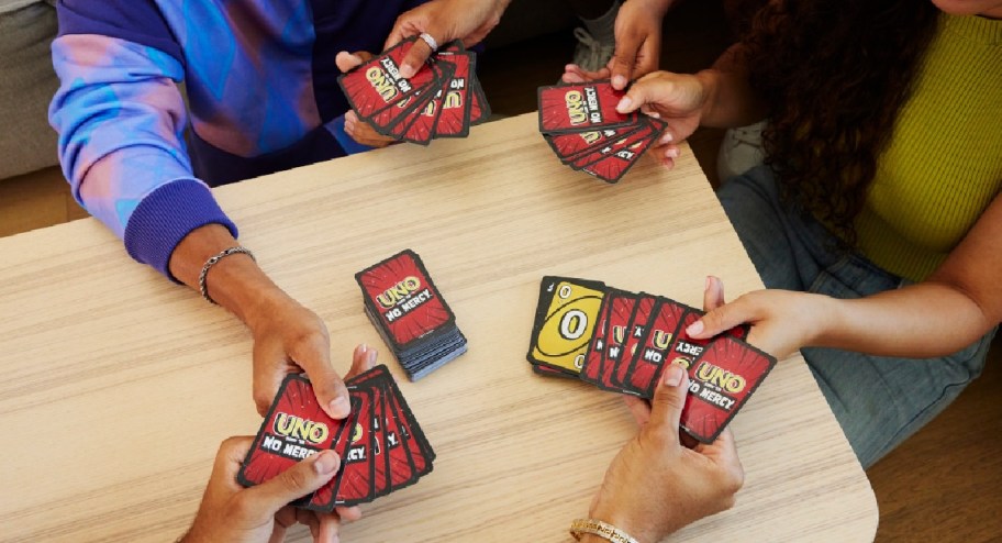 hands holding uno cards while playing with friends