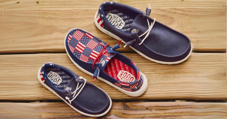 3 different red, white, blue Americana HEYDUDE shoes on a wood floor