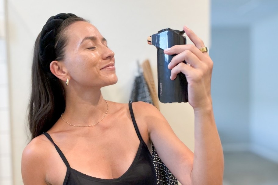 woman spraying face with airbrush sprayer