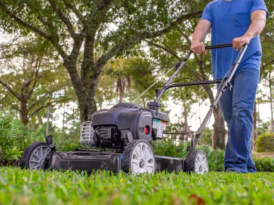 man using gray lawn mower on grass