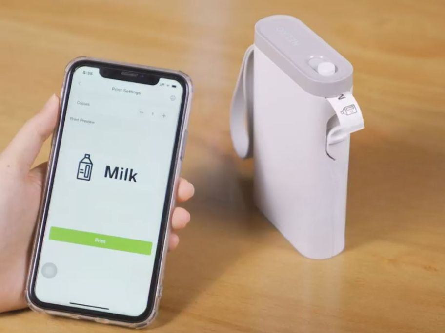 nelko label maker next to phone using app