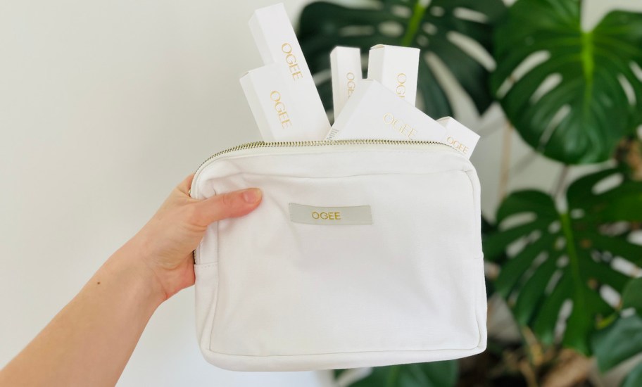 hand holding white canvas bag of ogee makeup