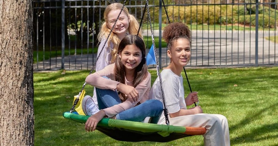 kids on round swing hanging by tree