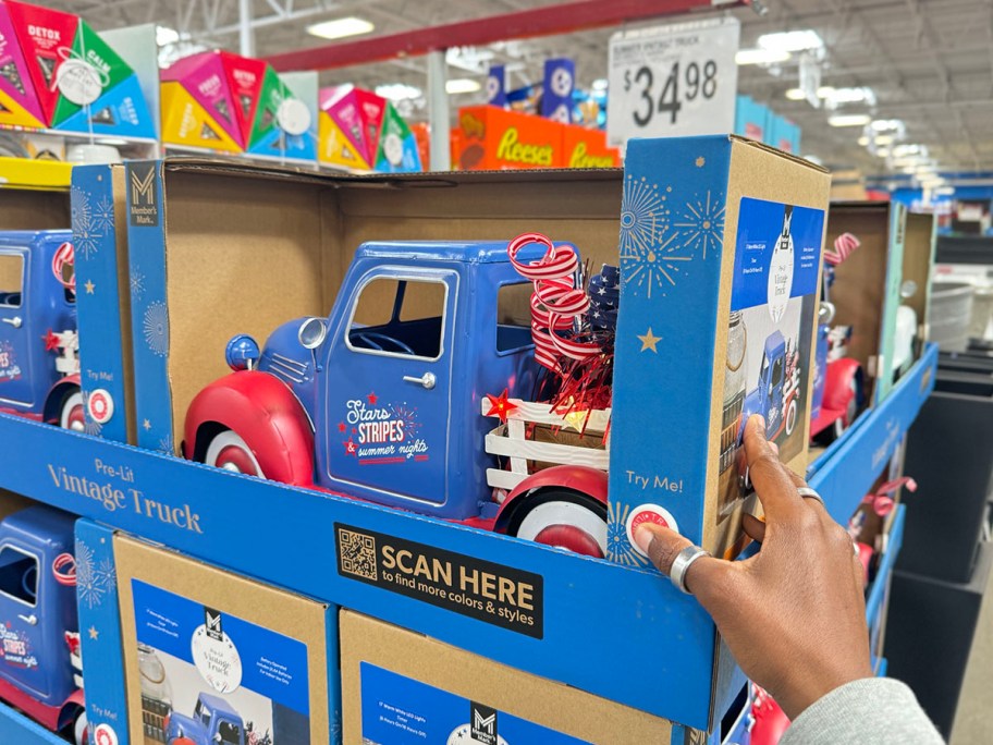 hand reaching for blue and red vintage firetruck on display in store