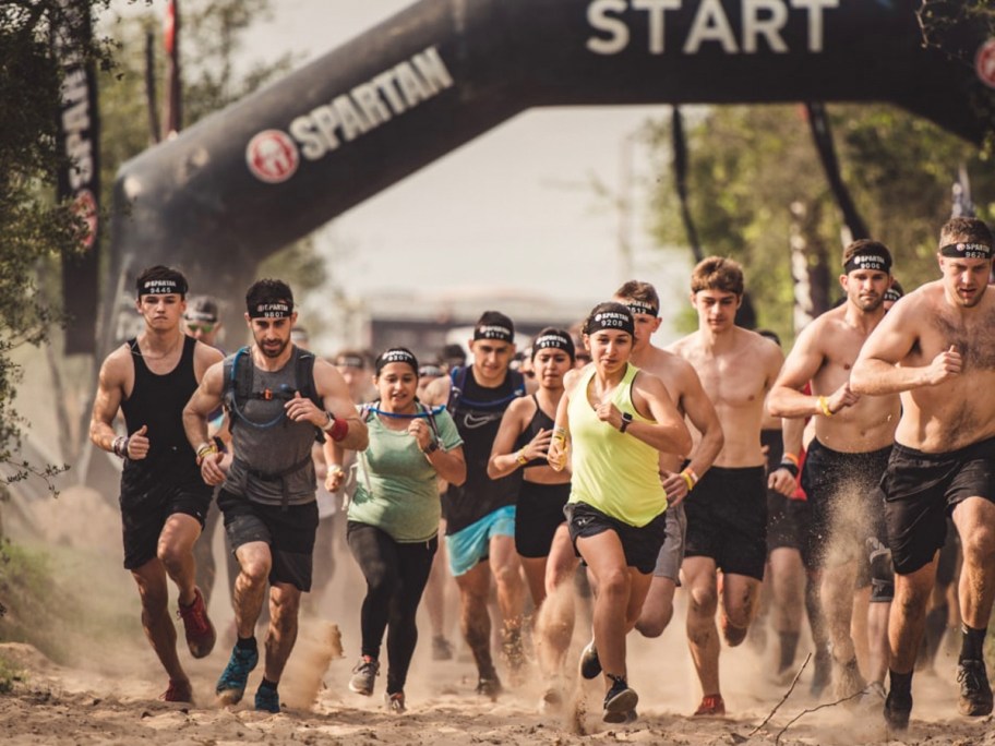 people running in front of spartan start sign