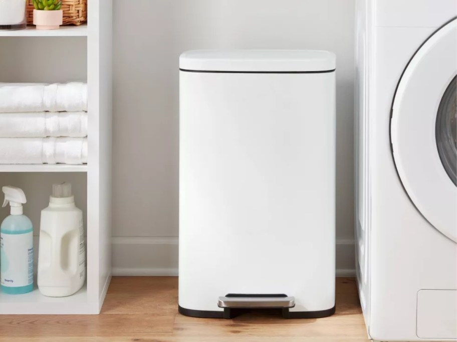 white metal step trash can in a laundry room