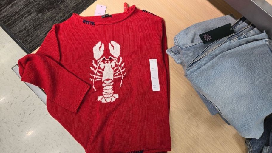 a red sweater with a white lobster graphic on the front