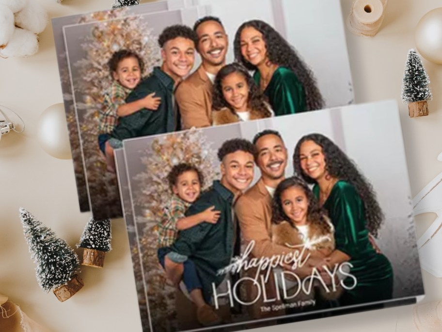 Christmas photo cards with a family picture and the words "Happiest Holidays" and the family's name on a Christmas themed background