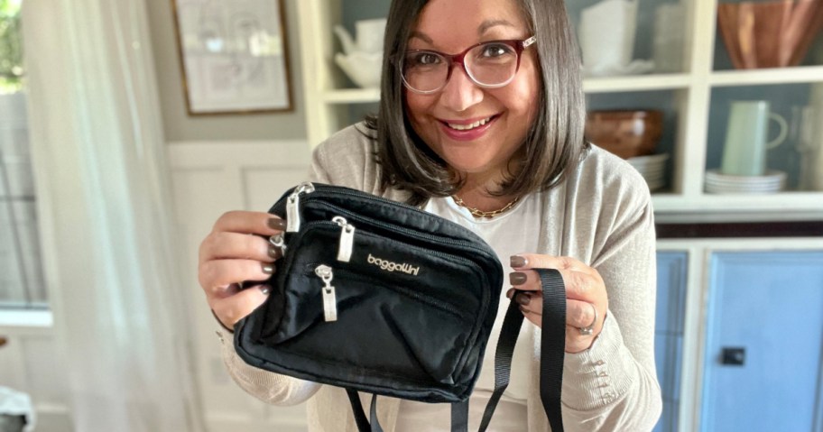 woman holding black triple zip bag