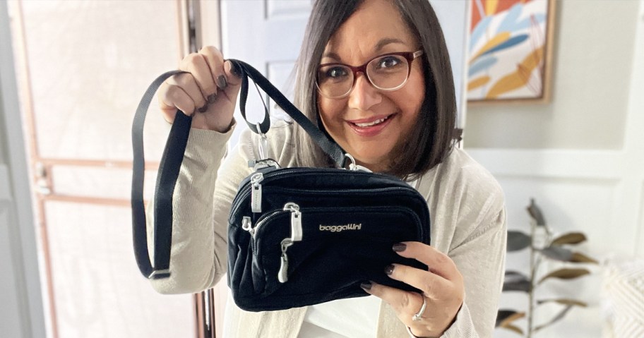 woman holding black baggallini bag