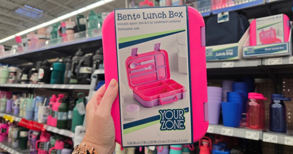 Person holding up hot pink bento lunchbox inside Walmart store