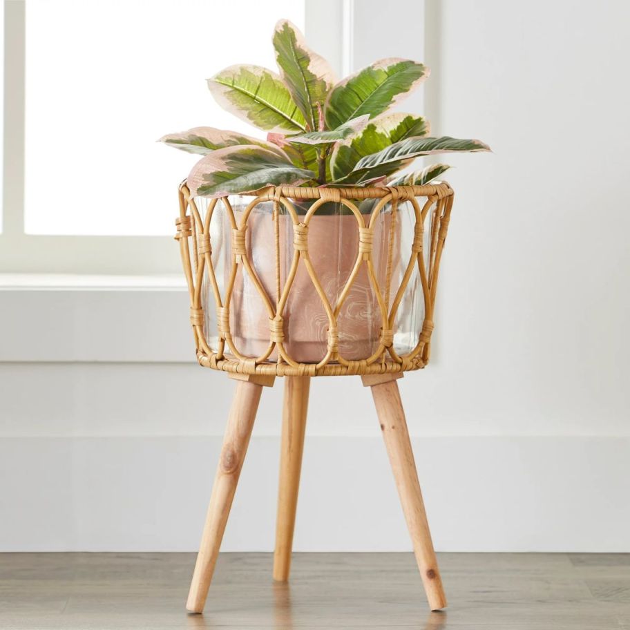 a round willow basket planter on a patio with a plant in it