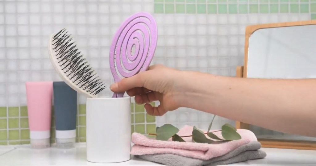 purple detangling brush in bathroom