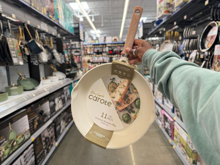 A hand holding a Carote Bon Appétit Collection 11" Nonstick Skillet in White