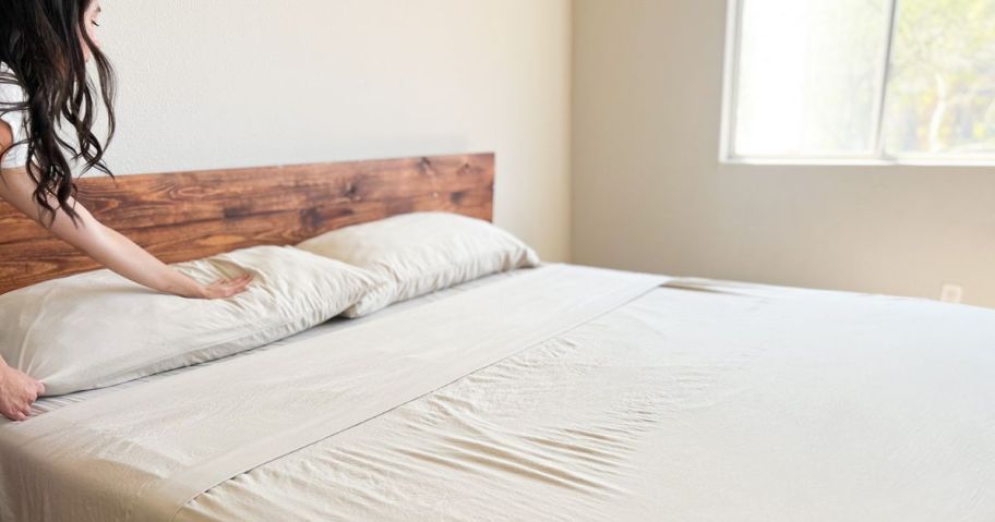 woman making a bed with casa Platino Sheets