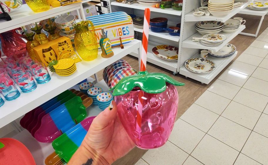 a pink plastic strawberry drink cup with striped straw