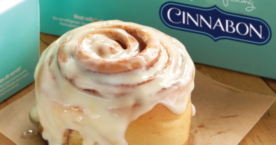 cinnamon roll next to Cinnabon boxes