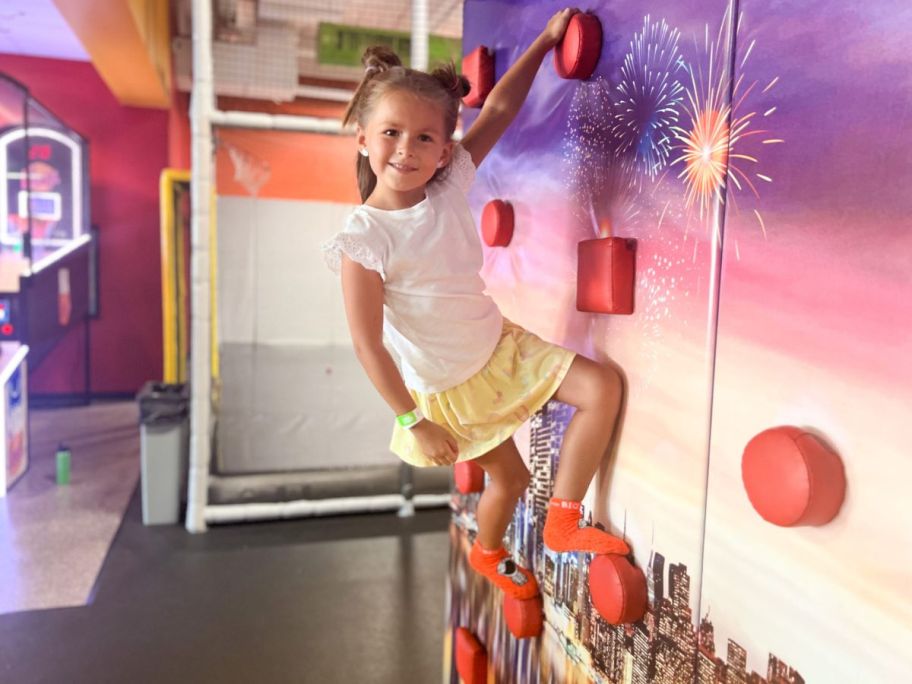 Little girl on a rock climbing wall