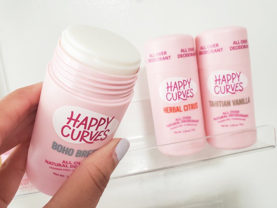 hand holding opened stick of Happy Curves Whole Body Deodorant