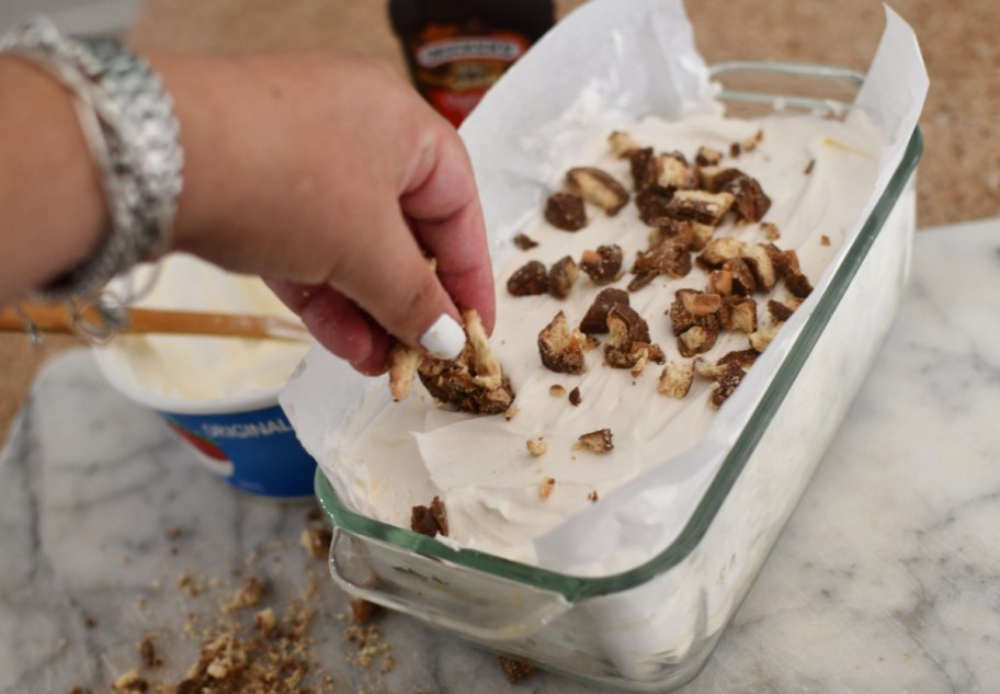 adding nuts to a homemade Ice cream sandwich cake