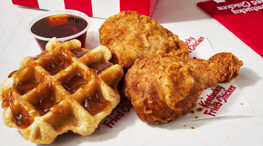 Chicken and Waffles next to syrup and a KFC bag