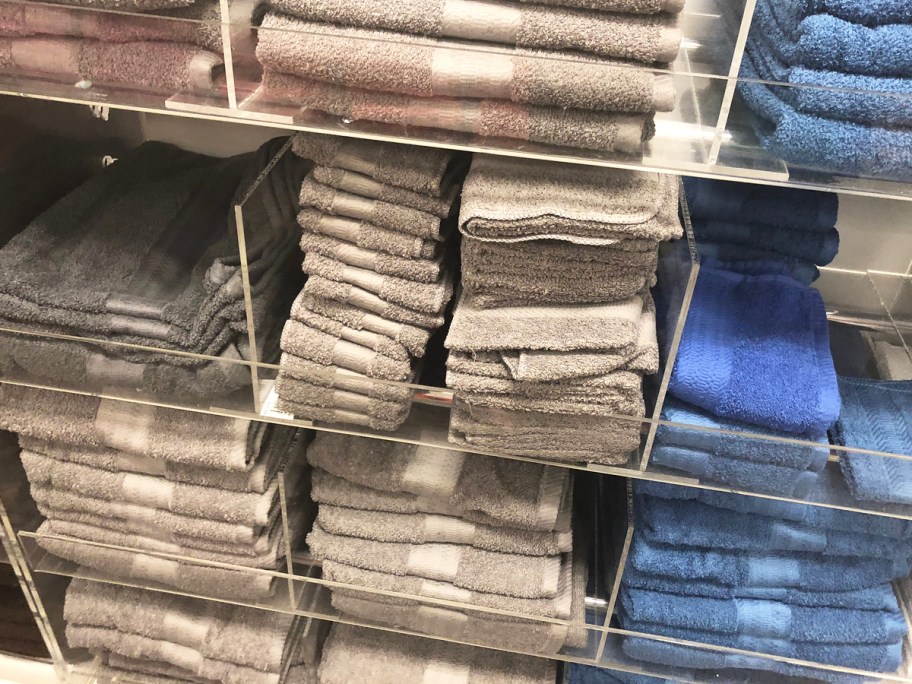 grey and blue hand towels and washcloths on store display shelves