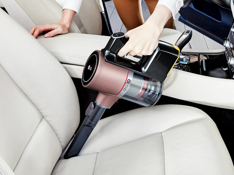 using rose gold stick vacuum to clean car