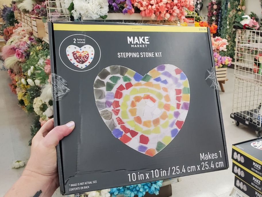 A hand holding a Make Market Heart Stepping Stones