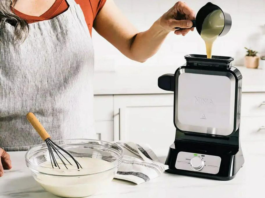 Woman pouring batter into the Ninja Neverstick Waffle Maker Pro