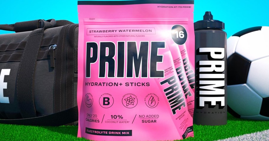 pink bag of Prime Hydration+ Sticks in strawberry watermelon flavor on field near soccer gear