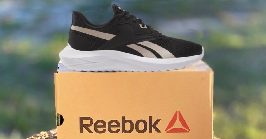 black reebok training shoe on top of its shoe box