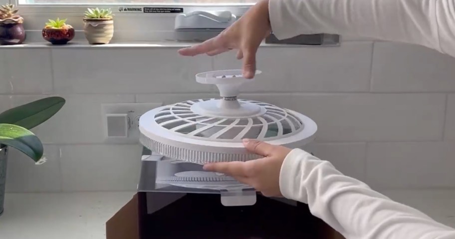 person unboxing Socket Ceiling Fan