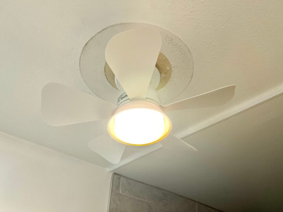 A hand holding a Socket Fan for the ceiling