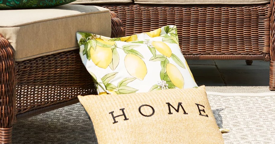 home throw pillow leaning against a lemon print throw pillow