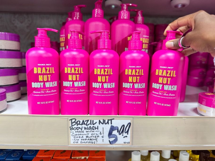 A hand grabbing a Trader Joe's Brazil Nut Body Wash