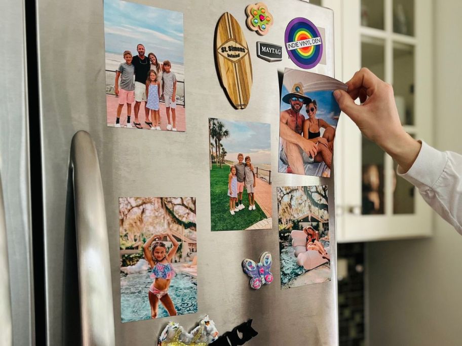 Hand peeling a Walgreens photo magnet from a fridge door