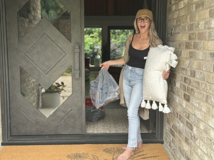 Collin holding up her Walmart Plus Grocery Delivery which was delivered right to her front porch