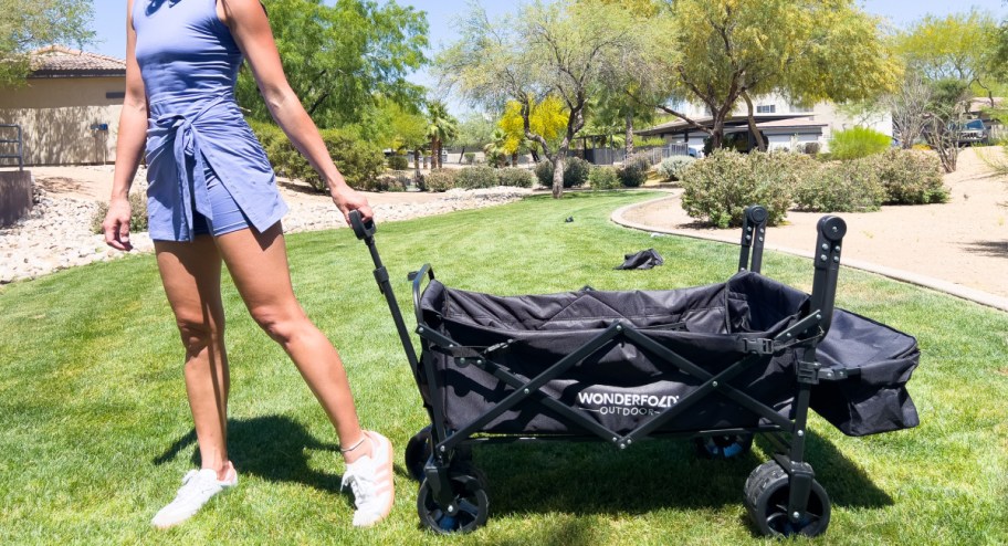 Woman pushing her wagonfold across the grass