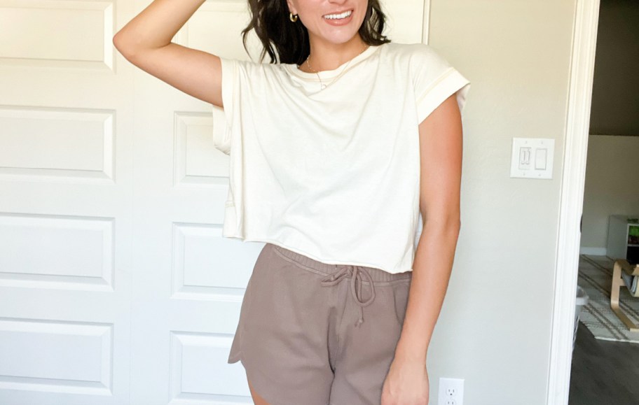 Woman wearing shirt and shorts laying on the wall