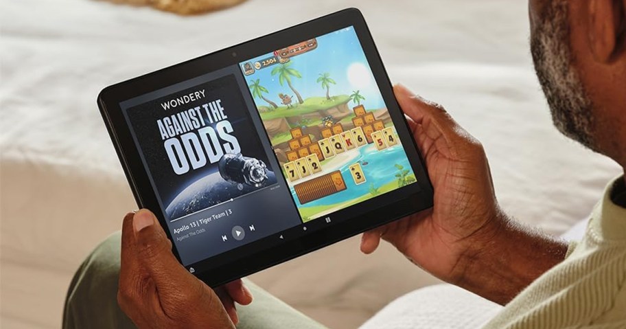 hand holding fire tablet with games on it