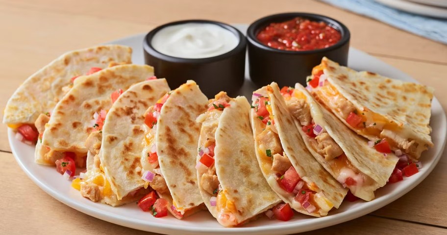 quesadilla on a plate with salsa and sour cream