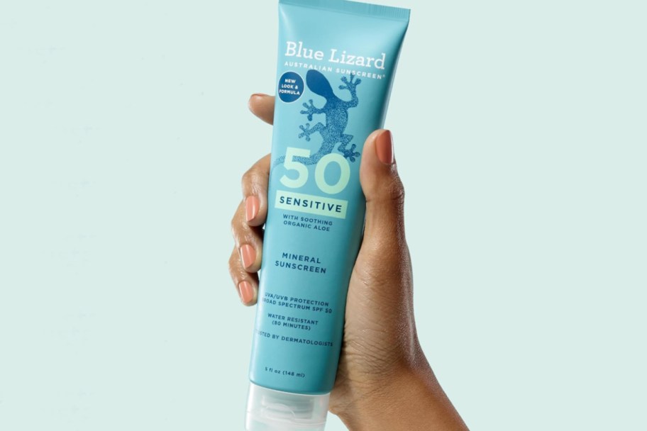 hand holding blue sunscreen tube 